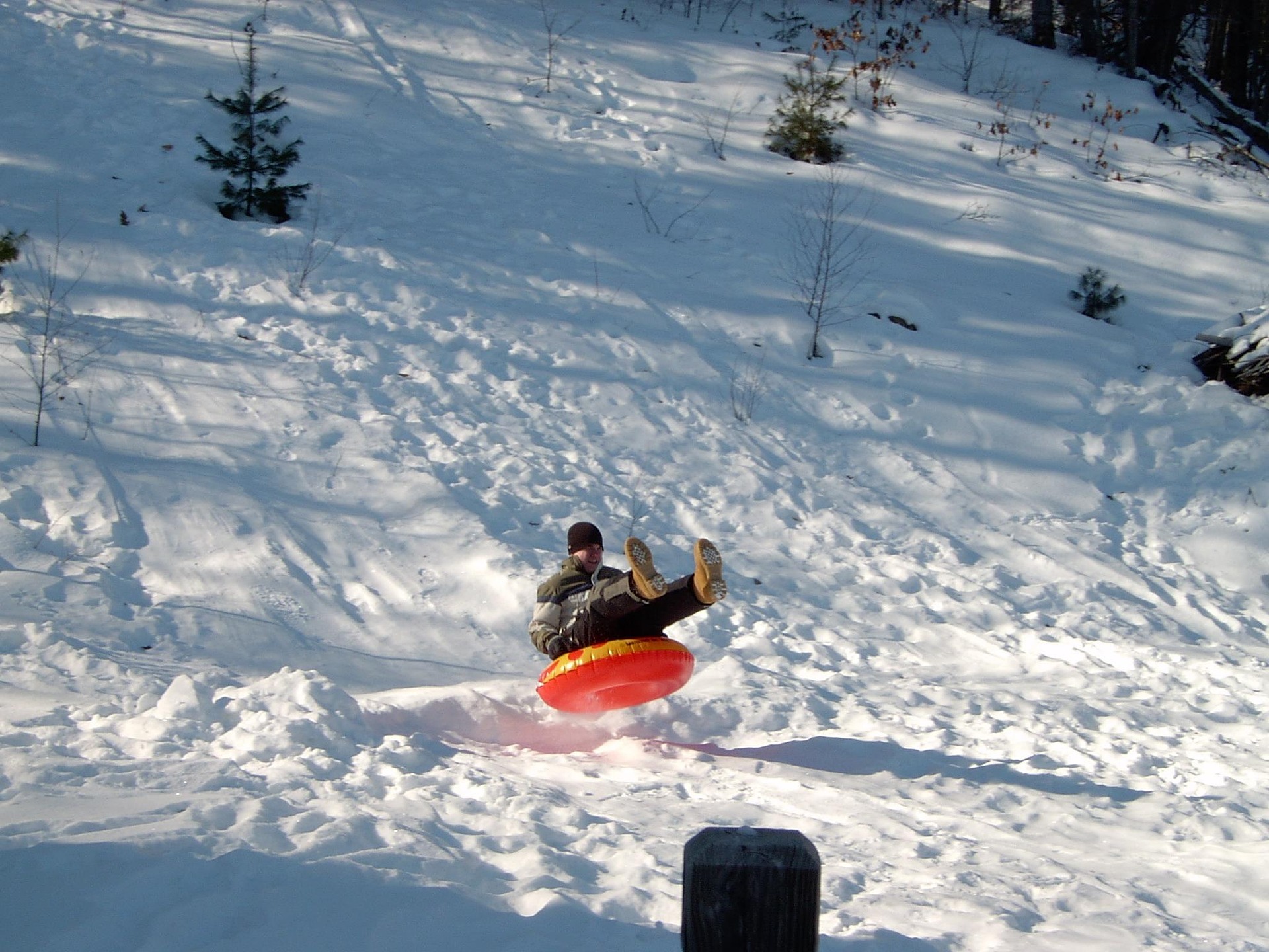 Person tubing down Olympic ski jump at high speed with astroturf surface